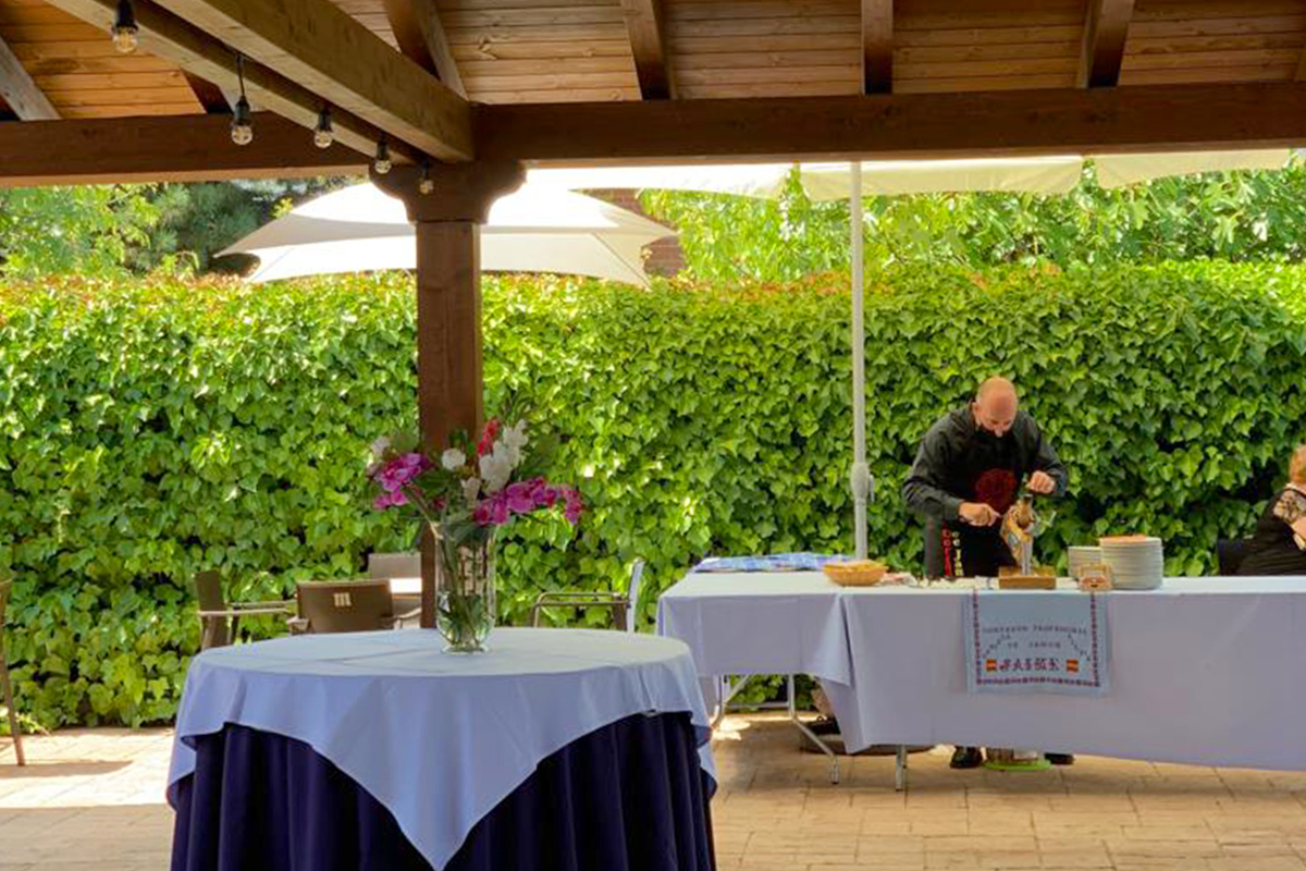 Terraza de Restaurante Zahorí con un camarero cortando jamón